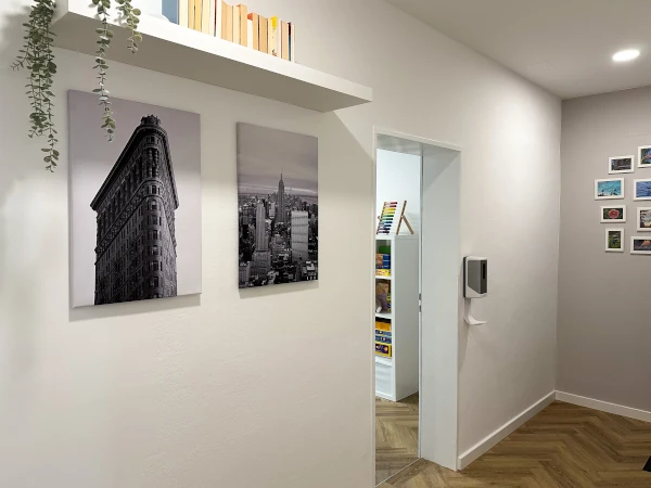 Flur mit Bildern von Gebäuden in New York und Blick in Therapiezimmer 1